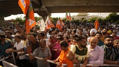 BJP supporters hold party flags outside a counting centre in Jammu on Tuesday. (AP) BJP supporters hold party flags outside a counting centre in Jammu on Tuesday. (AP)