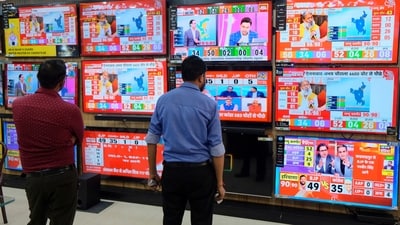 People watch TVs for Haryana results at a showroom, in Gurugram, Tuesday, Oct. 8, 2024.&nbsp; (PTI)