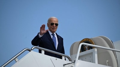 US President Joe Biden waves as he boards Air Force One at Joint Base Andrews in Maryland on October 5, 2024 before heading to South Bend, Indiana. (AFP)