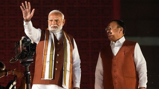 Prime Minister Narendra Modi and Union Minister and BJP National President JP Nadda greet the gathering at the party headquarters after the declaration of results for the Haryana and Jammu and Kashmir Assembly elections, in New Delhi. (PTI)