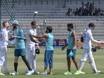 Players shake hands with each other at the end of the first Test cricket match.