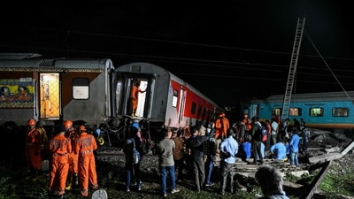 People watch as members of the National Disaster Response Force (NDRF) inspect the site after after several coaches of the Mysuru-Darbhanga Bagmati Express (12578) train derailed after ramming into the rear of a goods train at the Kavaraipettai Railway Station on October 12. (AFP) People watch as members of the National Disaster Response Force (NDRF) inspect the site after after several coaches of the Mysuru-Darbhanga Bagmati Express (12578) train derailed after ramming into the rear of a goods train at the Kavaraipettai Railway Station on October 12. (AFP)