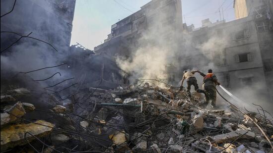 Rescue workers search for victims at the site of Thursday’s Israeli airstrike in Beirut on Friday. (AP)