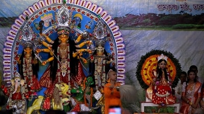 A young girl dressed as "Kumari" sits next to an idol of Hindu goddess Durga during the Durga Puja festival at a temple in Dhaka, Bangladesh, October 11, 2024. (REUTERS)