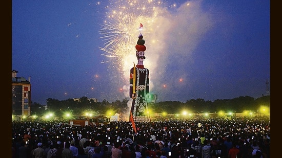 Crowds watch an effigy of Ravana going up in flames during Dussehra celebrations in Panchkula on Saturday. (Sant Arora/HT)