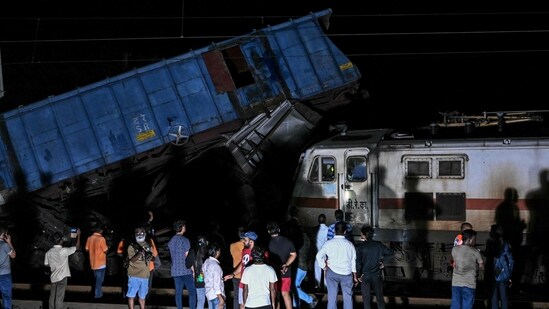People watch as official inspect the site after several coaches of the Mysuru-Darbhanga Bagmati Express train derailed. (AFP)