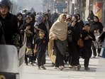 People stand at the site of a suicide bombing in Jacobabad, Sindh province, Pakistan, October 23, 2015. The suicide bomber killed at least 22 people during a Moharram procession by the minority Shia group.