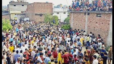 A crowd gathers in Rehuva village Monday, after arrival of the body of a 22-year-old man who was killed in communal violence during idol immersion procession, in Bahraich. (PTI Photo)