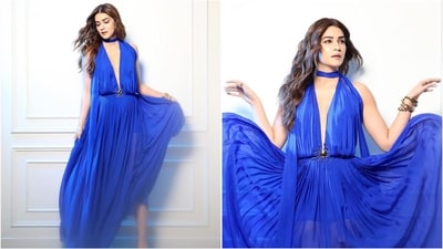 Kriti Sanon's recent glamorous look features a blue plunging neckline gown, styled with a golden sun brooch and stacked bangles. (Instagram) Kriti Sanon's recent glamorous look features a blue plunging neckline gown, styled with a golden sun brooch and stacked bangles. (Instagram)