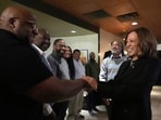 Democratic presidential nominee Vice President Kamala Harris, right, greets Ishmael Trainor, owner of Legenderie Records and Coffee House, a Black-owned small business in Erie, Pa., during a campaign stop, Monday, Oct. 14, 2024. (AP Photo/Jacquelyn Martin)