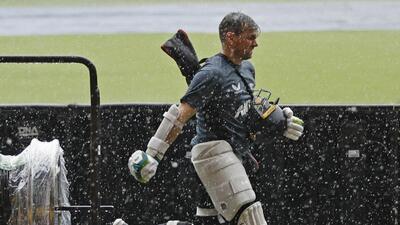 New Zealand's captain Tom Latham runs back towards the dressing room as it rains during a training session in Bengaluru. (AP) New Zealand's captain Tom Latham runs back towards the dressing room as it rains during a training session in Bengaluru. (AP)