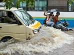 Commuters wade through a flooded road following heavy rainfall in Bengaluru on October 15, 2024. (Photo by Idrees MOHAMMED / AFP) Commuters wade through a flooded road following heavy rainfall in Bengaluru on October 15, 2024. (Photo by Idrees MOHAMMED / AFP)