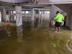 Residents walk through waterlogged area after water entered an apartment complex following heavy rainfall in Bengaluru on Wednesday. Residents walk through waterlogged area after water entered an apartment complex following heavy rainfall in Bengaluru on Wednesday.