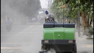 A Noida authority worker cleaning dust from a road using a mechanical sweeping machine. (HT Archive) A Noida authority worker cleaning dust from a road using a mechanical sweeping machine. (HT Archive)