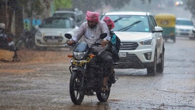 People commute amid rains due to Spawn cyclone in Bengaluru on Tuesday. (PTI)