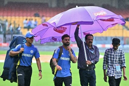 India�s Virat Kohli (2L) and Yashasvi Jaiswal (L) walk across the field as it rains before the start of the first day play of the first Test cricket match between India and New Zealand at the M. Chinnaswamy Stadium in Bengaluru on October 16, 2024. (Photo by Idrees MOHAMMED / AFP) / -- IMAGE RESTRICTED TO EDITORIAL USE - STRICTLY NO COMMERCIAL USE -- (AFP)