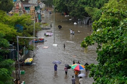People wade through a flooded street during heavy rain in Chennai. (AP) People wade through a flooded street during heavy rain in Chennai. (AP)
