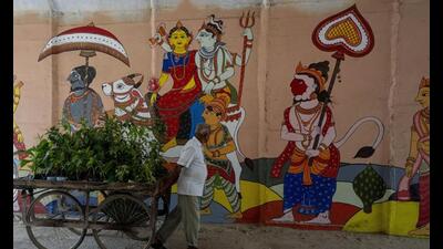 A vendor looks at a painting under the railway bridge bypass during the preparations for Mahakumbh 2025. (AP Photo) A vendor looks at a painting under the railway bridge bypass during the preparations for Mahakumbh 2025. (AP Photo)