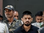 Policemen escort Lawrence Bishnoi in New Delhi in April 2023. (Reuters)