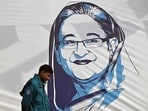A policeman walks past a portrait of former Bangladesh's prime minister Sheikh Hasina in Dhaka on January 8, 2024. A policeman walks past a portrait of former Bangladesh's prime minister Sheikh Hasina in Dhaka on January 8, 2024.