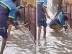 The footage shows two BBMP workers standing in knee-deep water, and attempting to unclog a drain with their bare hands, without any protective gear. The footage shows two BBMP workers standing in knee-deep water, and attempting to unclog a drain with their bare hands, without any protective gear.