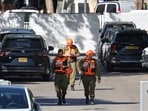 Members of the Israeli security forces walk along a street leading to Prime Minister Benjamin Netanyahu's residence in Caesarea on October 19, 2024.
