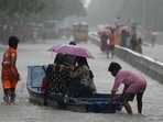 People use a boat on a flooded street to reach a safer place during heavy rains in Chennai on Wednesday. (AP)