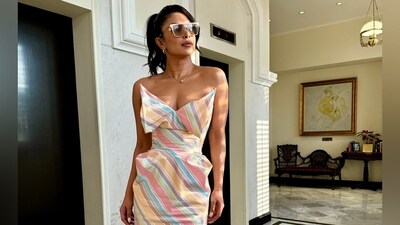 Priyanka Chopra posted a photo of herself wearing a colourful dress, sunglasses and white heels. She stood inside a room in the candid photo. Priyanka Chopra posted a photo of herself wearing a colourful dress, sunglasses and white heels. She stood inside a room in the candid photo.