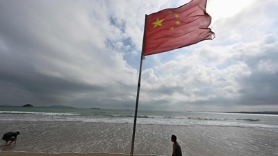 A Chinese flag flutters in the wind as people visit a beach on Pingtan island, the closest point in China to Taiwan�s main island, in China�s Southeast Fujian province on October 15, 2024. China insisted on October 14 it would never renounce the "use of force" to take control of Taiwan, after ending a day of military drills around the self-ruled island that Beijing said was a "stern warning" to "separatist" forces. (Photo by ADEK BERRY / AFP) (AFP)