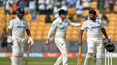 India's Sarfaraz Khan (R) is being greeted by New Zealand's captain Tom Latham (C) after his dismissal during the fourth day of the first Test cricket match between India and New Zealand at the M. Chinnaswamy Stadium in Bengaluru (AFP) India's Sarfaraz Khan (R) is being greeted by New Zealand's captain Tom Latham (C) after his dismissal during the fourth day of the first Test cricket match between India and New Zealand at the M. Chinnaswamy Stadium in Bengaluru (AFP)