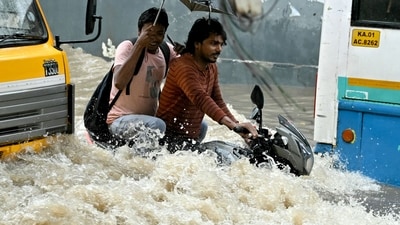 Commuters wade through a flooded road following heavy rainfall in Bengaluru. (AFP) Commuters wade through a flooded road following heavy rainfall in Bengaluru. (AFP)