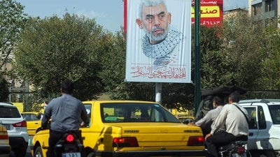 People drive past a banner bearing a portrait of Hamas' slain leader Yahya Sinwar at at a street in Tehran, on October 19, 2024. Iran's supreme leader Ayatollah Ali Khamenei said on October 19 that Hamas was alive and will survive despite the death of its leader Yahya Sinwar in an Israeli military operation in Gaza. (Photo by AFP) (AFP) People drive past a banner bearing a portrait of Hamas' slain leader Yahya Sinwar at at a street in Tehran, on October 19, 2024. Iran's supreme leader Ayatollah Ali Khamenei said on October 19 that Hamas was alive and will survive despite the death of its leader Yahya Sinwar in an Israeli military operation in Gaza. (Photo by AFP) (AFP)