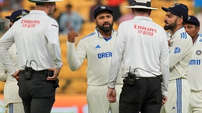 Indian captain Rohit Sharma and other players interact with umpires after bad light stopped play on the fourth day of the first test cricket match between India and New Zealand (PTI) Indian captain Rohit Sharma and other players interact with umpires after bad light stopped play on the fourth day of the first test cricket match between India and New Zealand (PTI)