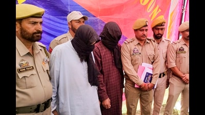 Police personnel with two terrorists arrested in connection with the several grenade attack cases, in Poonch district, on Saturday. (PTI) Police personnel with two terrorists arrested in connection with the several grenade attack cases, in Poonch district, on Saturday. (PTI)