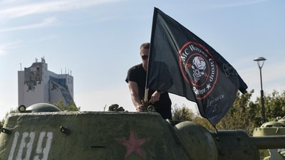 A man mounts a flag of Wagner group on top of an old tank exhibited at the Leninist Komsomol park in Donetsk, Russian-controlled Ukraine, on October 1, 2023, (Photo by STRINGER / AFP) (AFP) A man mounts a flag of Wagner group on top of an old tank exhibited at the Leninist Komsomol park in Donetsk, Russian-controlled Ukraine, on October 1, 2023, (Photo by STRINGER / AFP) (AFP)