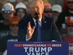 Former US President and Republican presidential candidate Donald Trump speaks behind bulletproof glass during a campaign rally at Arnold Palmer Regional Airport in Latrobe, Pennsylvania, October 19, 2024. (Photo by Jim WATSON / AFP)