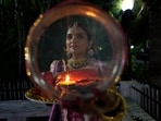 Karwa Chauth moon time live: A woman looks at the moon through a sieve as part of a ritual to break her fast during Karwa Chauth festival in Jammu.(AP)