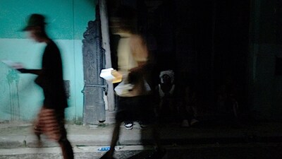 People walk using lights from a car during the second day of the nationwide blackout in Havana October 19, 2024. Hurricane Oscar is due to hit the island of Cuba imminently, with the risk of further affecting the population, who are spending their second night without electricity due to a giant blackout. (Adalberto Roque/AFP) People walk using lights from a car during the second day of the nationwide blackout in Havana October 19, 2024. Hurricane Oscar is due to hit the island of Cuba imminently, with the risk of further affecting the population, who are spending their second night without electricity due to a giant blackout. (Adalberto Roque/AFP)