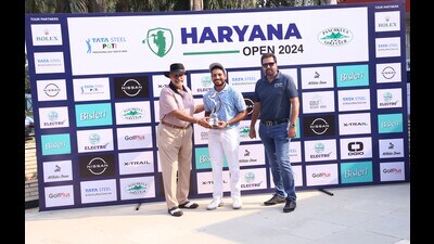 Haryana Open 2024 winner Varun Parikh receiving the trophy from Panchkula Golf Club general manager Col AS Dhillon (left) and PGTI CEO Uttam Singh Mundy. (HT Photo)