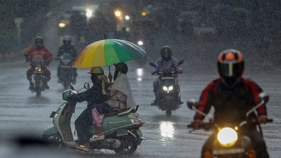 Commuters move amid rainfall at Cubbon Road, in Bengaluru. (PTI)