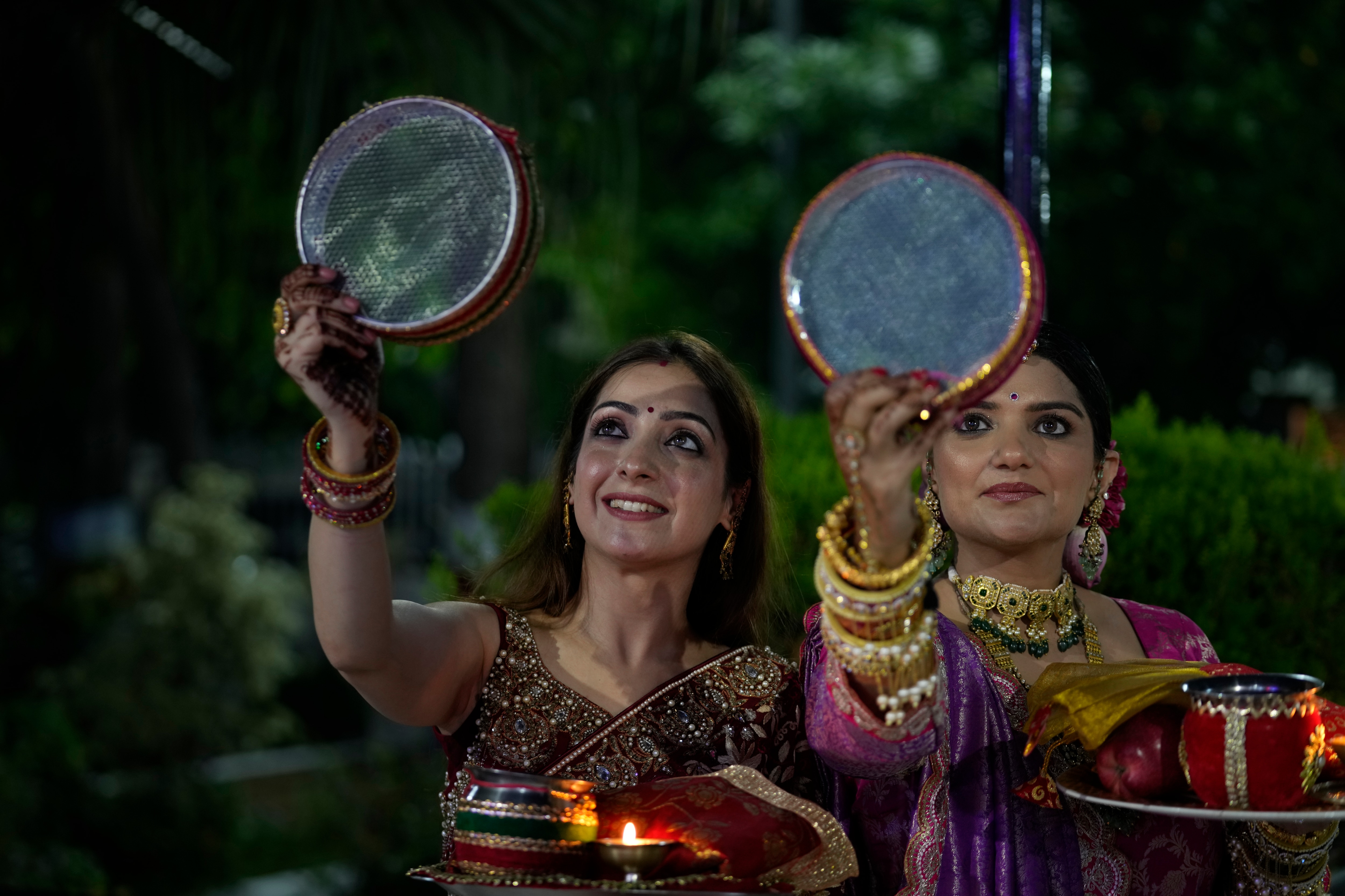 Married Hindu women look at the moon through a sieve as part of a ritual to break her fast during Karva Chauth festival in Jammu, India, Sunday, Oct. 20, 2024. (AP Photo/Channi Anand) (AP)