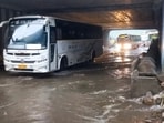 Vehicles move on a waterlogged road after heavy rain, in Bengaluru, Monday, 