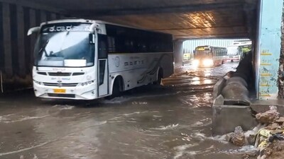 Vehicles move on a waterlogged road after heavy rain in Bengaluru on Monday. (PTI) Vehicles move on a waterlogged road after heavy rain in Bengaluru on Monday. (PTI)