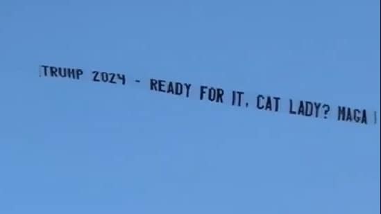 During her Miami concert, a plane carried a pro-Trump banner, showcasing the ongoing conflict between the singer and the former president amidst her Eras Tour. (@TONYxTWO/X)