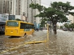 A school bus moves through a flooded road after heavy rains in Bengaluru.