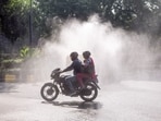 Commuters pass by as an anti-smog vehicle sprinkles water to curb air pollution amid deteriorating air quality, in New Delhi. Commuters pass by as an anti-smog vehicle sprinkles water to curb air pollution amid deteriorating air quality, in New Delhi.