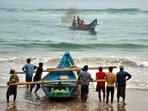 Fishermen shift their boats in preparations for Cyclone Dana in Puri on Monday.