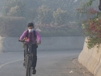 Student rides a bicycle to school amid dense smog in Lahore.