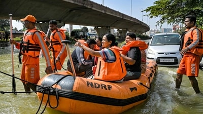National Disaster Response Force (NDRF) personnel rescue residents from a flooded locality following heavy rainfall, in Bengaluru on October 22, 2024.&nbsp; (AFP)