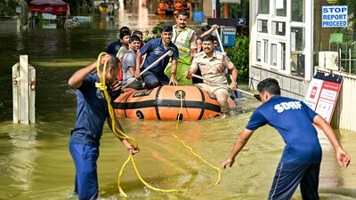 State Disaster Response Force (SDRF) personnel and police rescue residents from a flooded locality following heavy rainfall, in Bengaluru. (AFP)